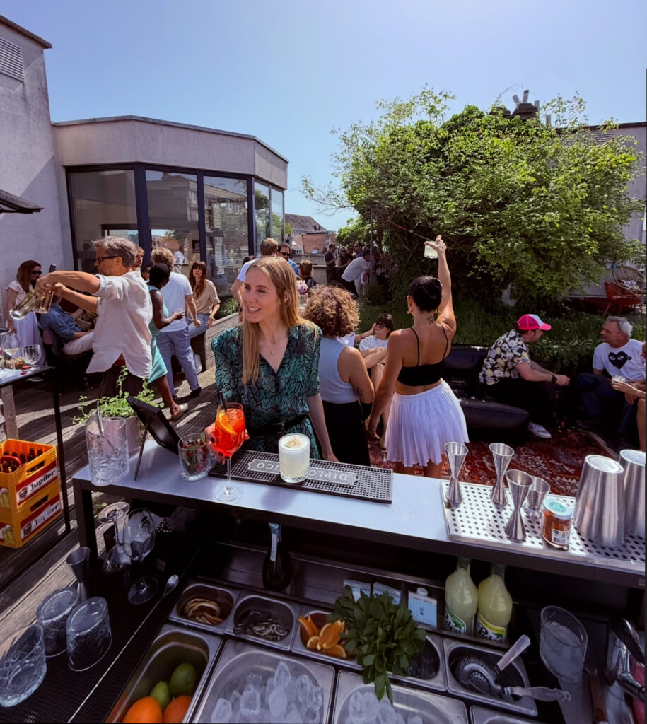 Invités réunis autour d’un bar lors d’un événement sur une terrasse