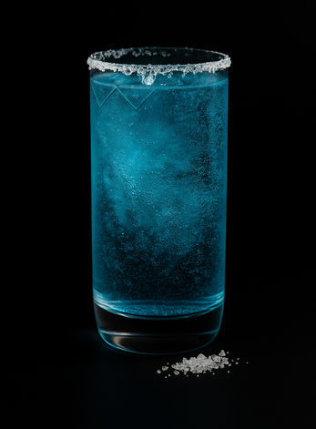 Cocktail bleu pétillant servi dans un verre givré de sel.