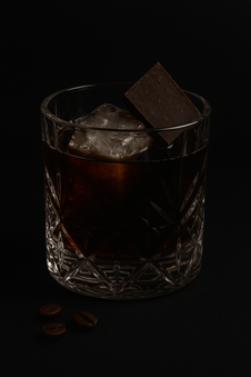 Cocktail aux couelrus de chocolat noir dans un verre a whisky