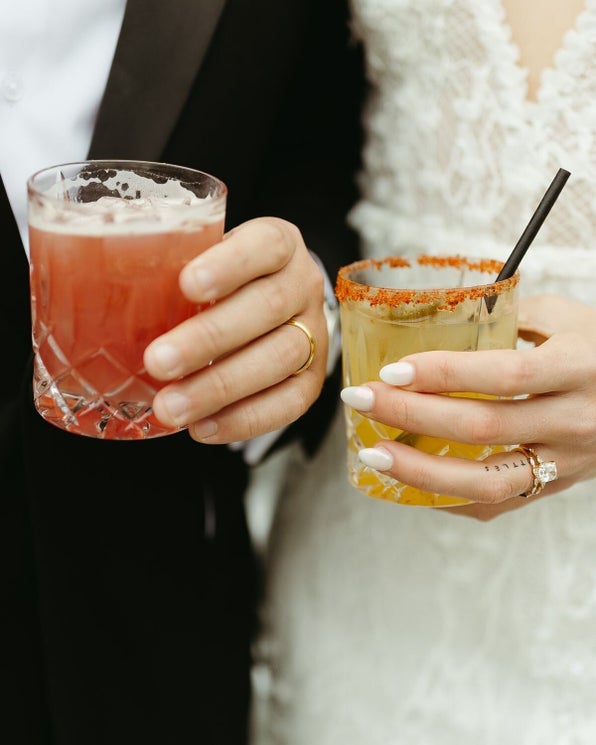 Couple tenant deux cocktails lors d’une réception de mariage