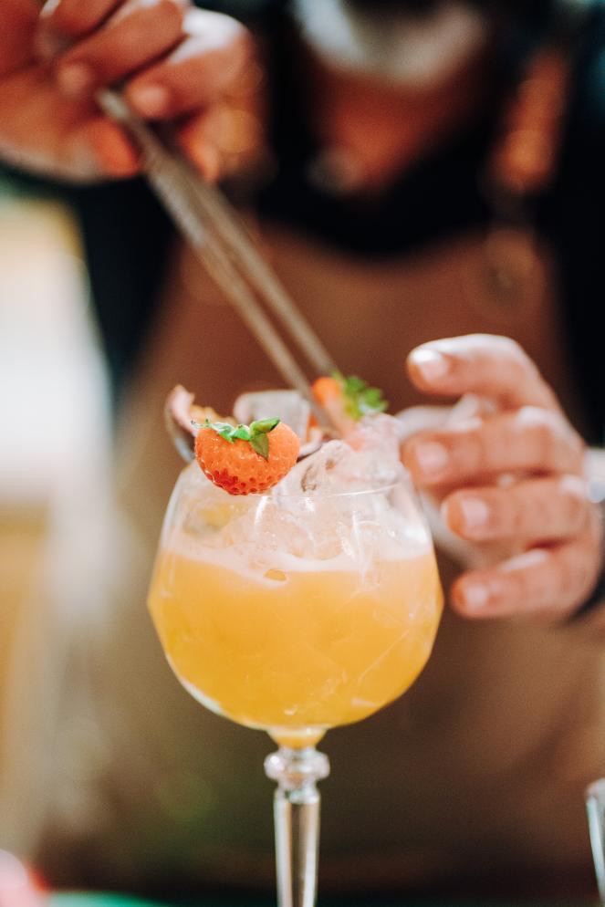 Cocktail orange premium garni d’une fraise, préparé par Nomad Bar