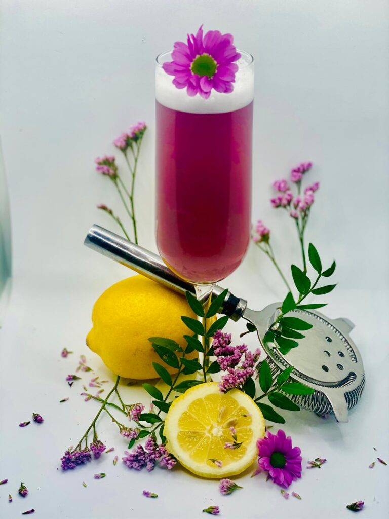 Cocktail premium rose avec mousse et fleur violette