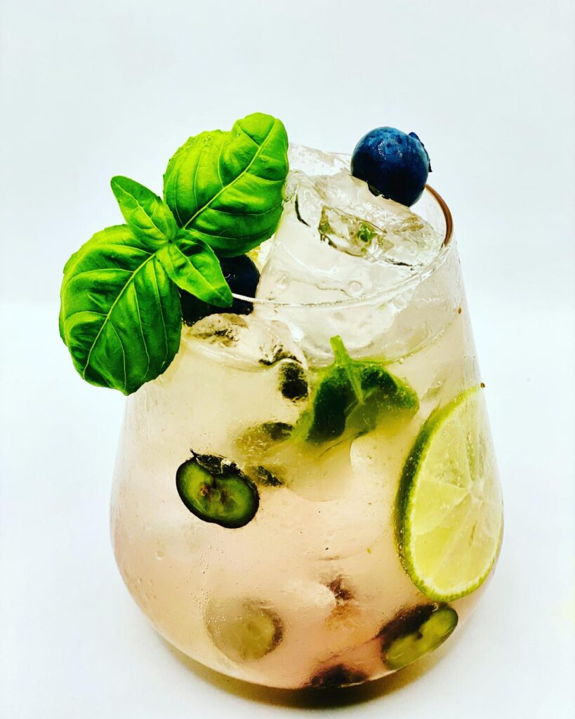 Cocktail premium avec citron vert, myrtilles et basilic