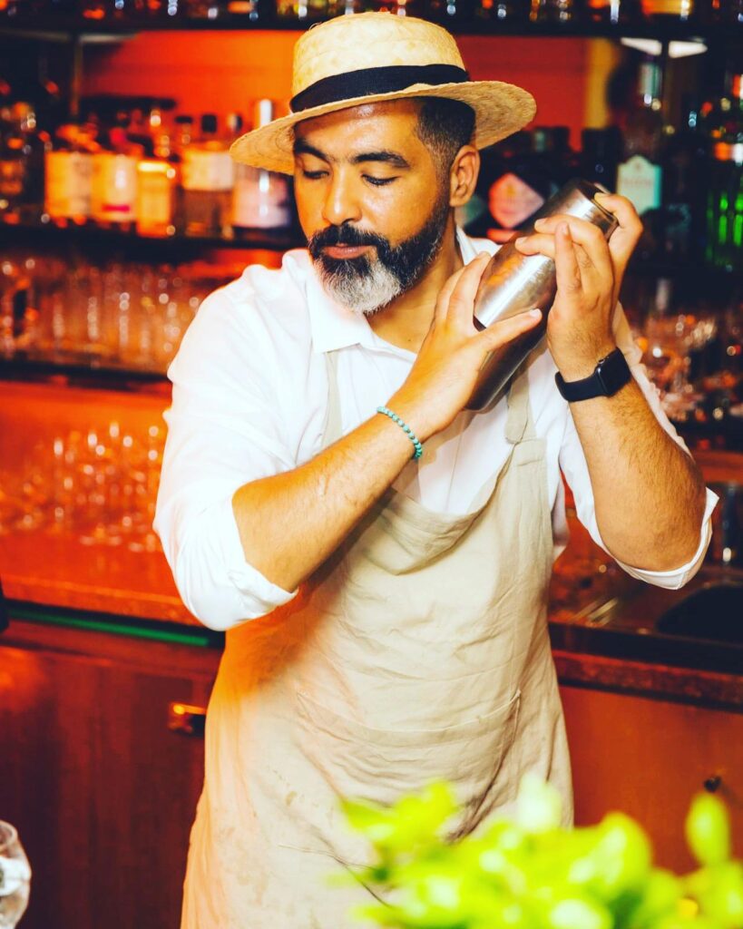 Bartender secouant un shaker derrière le bar