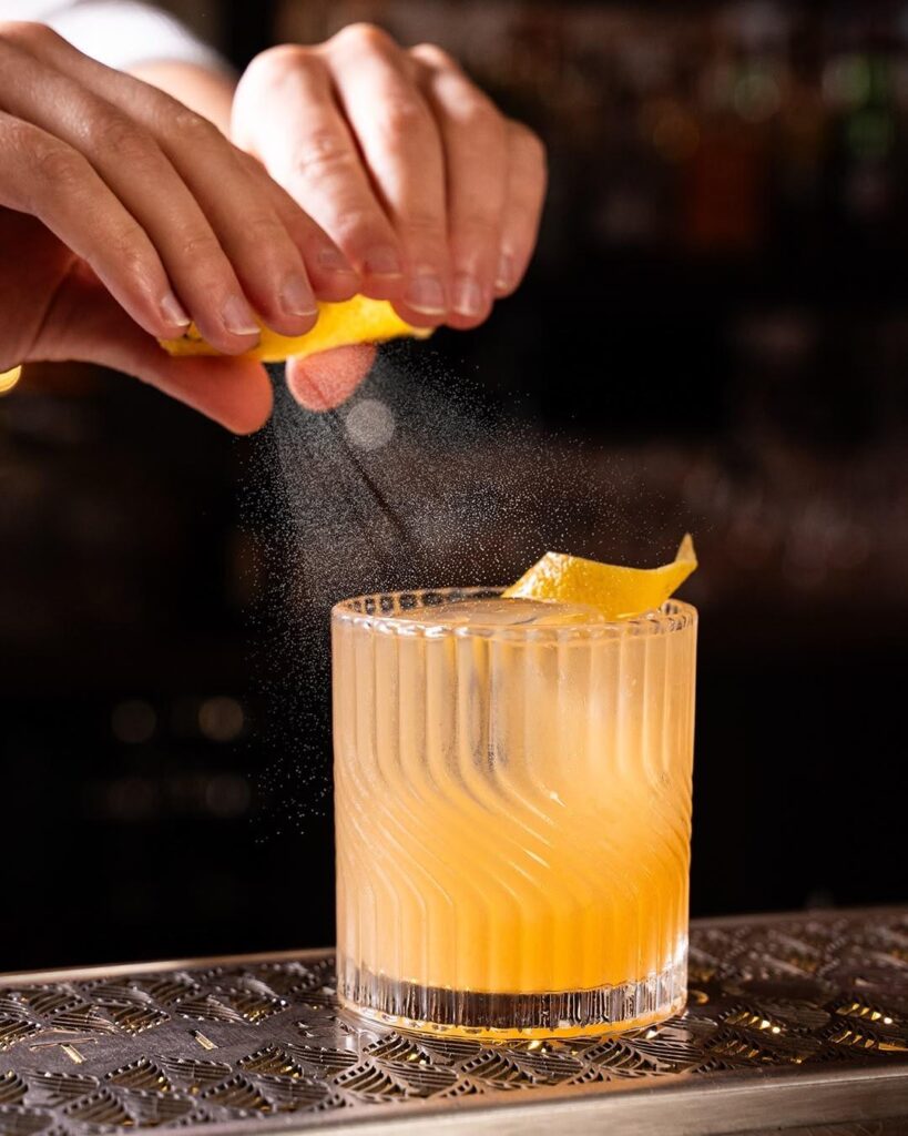 Finition d’un cocktail avec un zeste d’agrume