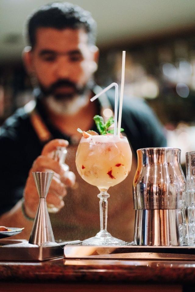 Barman Nomad Bar préparant un cocktail signature devant les invités