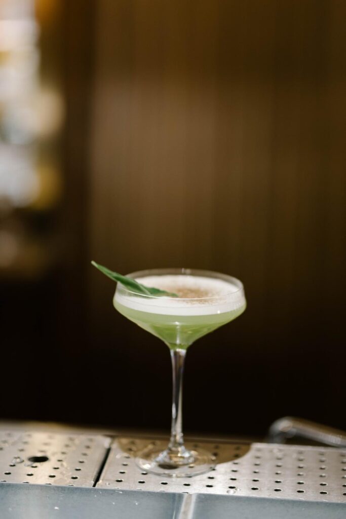 Cocktail vert servi dans un verre à martini