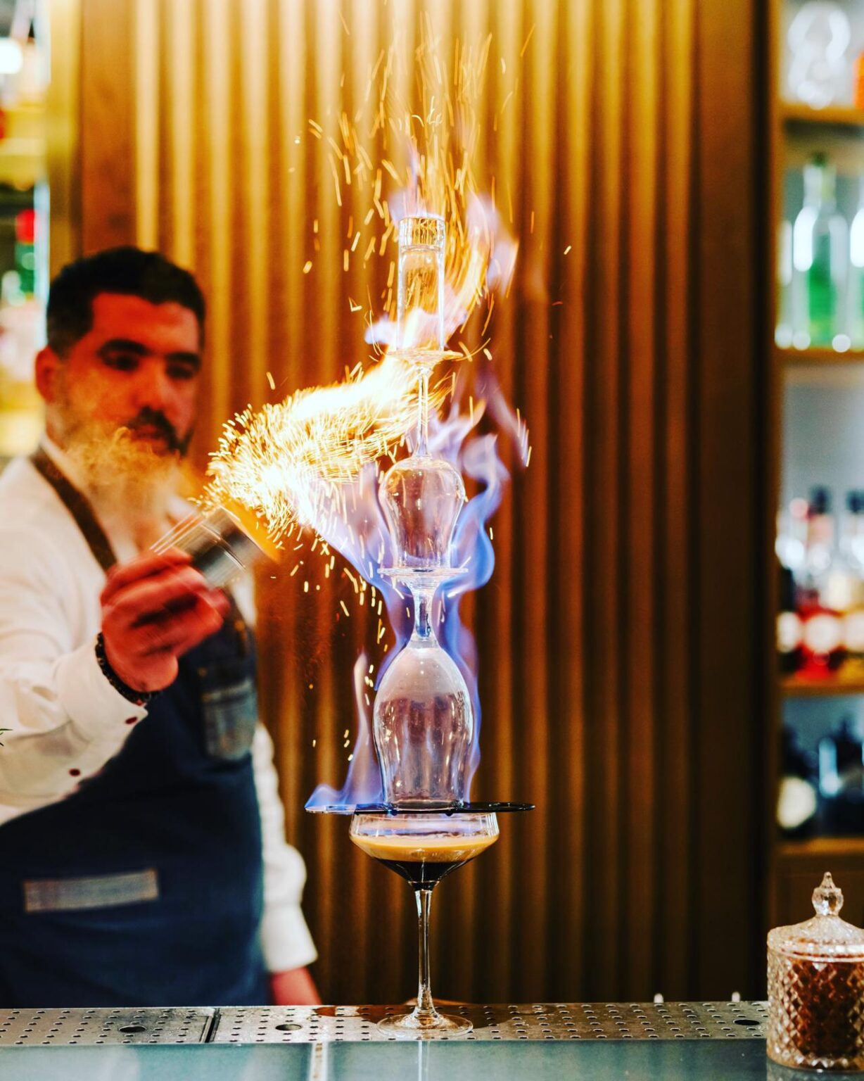 Barman réalisant une animation de cocktail flambé