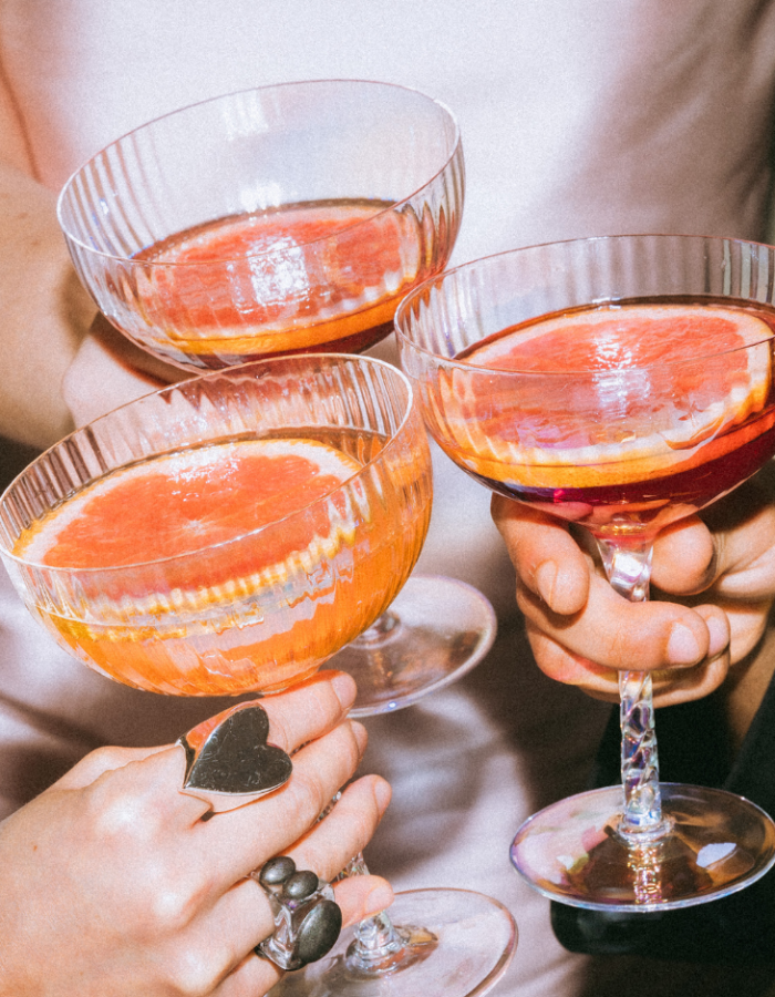 Invités trinquant avec des cocktails aux agrumes