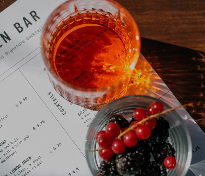 Cocktail signature accompagné de fruits rouges sur une carte de cocktails