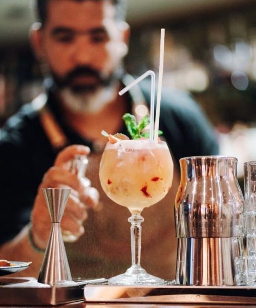 Barman Nomad Bar préparant un cocktail signature devant les invités